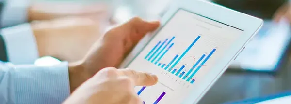 Persona analizando gráficos de datos en una tablet, representando la digitalización y toma de decisiones estratégicas.