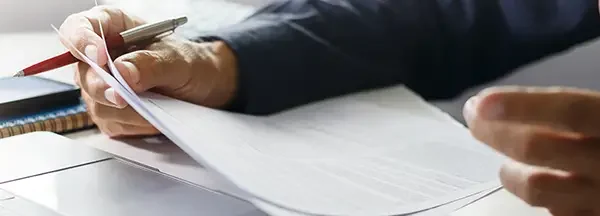 Persona en una reunión de trabajo revisando documentos y tomando decisiones estratégicas.