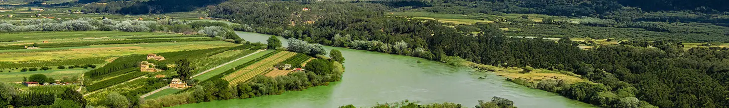 Vista aérea de un río rodeado de campos de cultivo y zonas boscosas.
